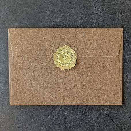 Brown handcrafted envelope with a exclusive golden wax seal on a dark gray background