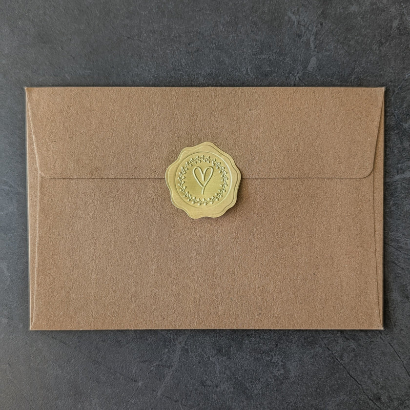 Brown handcrafted envelope with a exclusive golden wax seal on a dark gray background